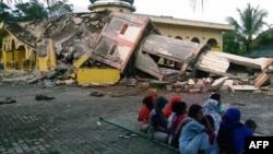 Indoneziýanyň demirgazygyndaky Açeh welaýatynda bolan suwasty ýertitremeden soň, köçede oturan ýaşaýjylar. 7-nji dekabr, 2016 ý.