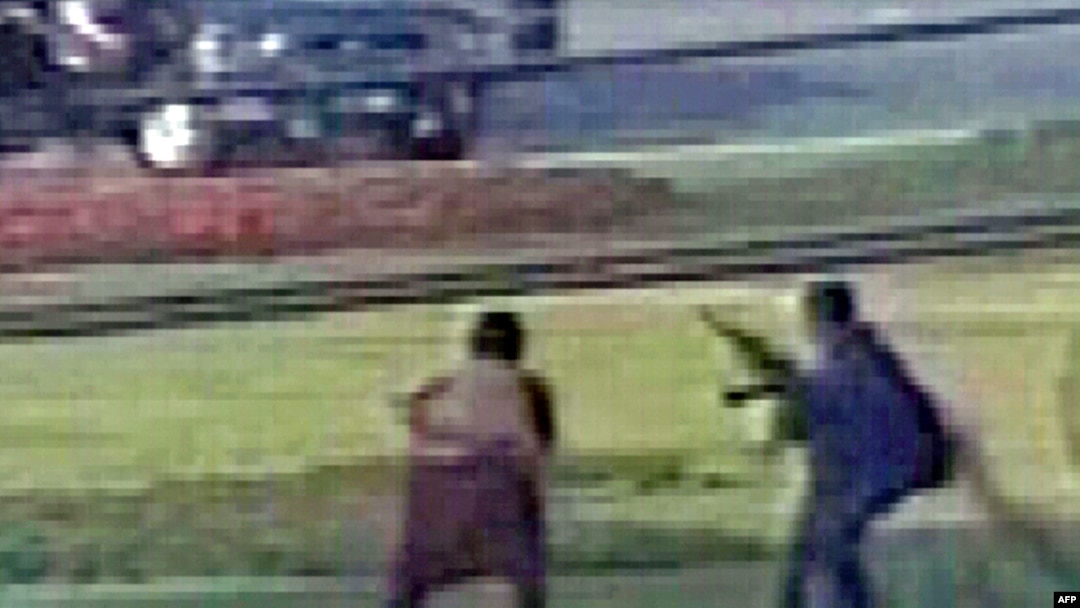 A TV video grab shows the unidentified gunmen firing their weapons during an attack on a vehicle carrying the Sri Lankan cricket team in Lahore on March 3.