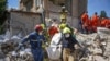 Рятувальники несуть тіло людини, знайдене під завалами на місці ураження житлового будинку внаслідок російського ракетного удару у Києві, Україна, 9 липня 2024 року