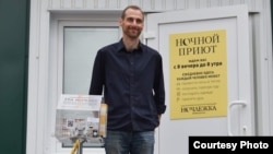 Grigorij Szverdlin mögötte egy korábbi projektje, a hajléktalanokat segítő Éjjeli menedékhely plakátjával