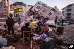 People gather near collapsed buildings in Golbasi, in Adiyaman Province, in southern Turkey on February 8.