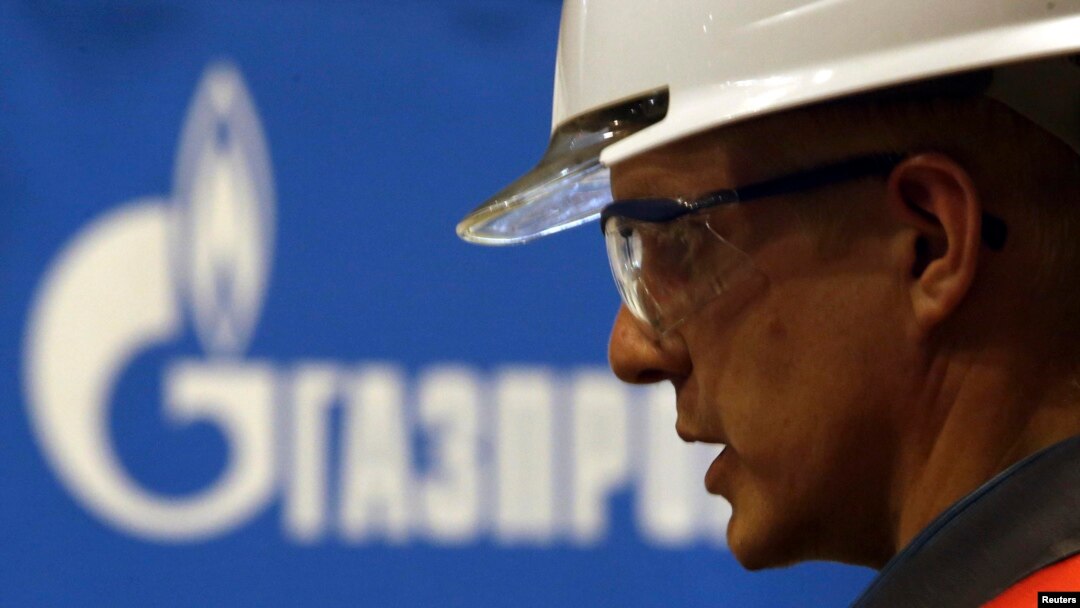 Un muncitor care lucrează pentru Gazprom surpins lângă logo-ul companiei