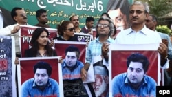 During a rally in Karachi, people hold portraits of Pakistani student Mashal Khan, who was killed by a mob for alleged blasphemy at Abdul Wali Khan University in April. 