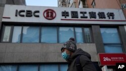Një person duke kaluar pranë Bankës Komerciale dhe Industriale të Kinës (ICBC), e cila u hakua nga Lockbit së fundmi.