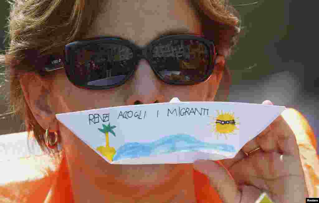 Romada Amnesty İnternational təşkilatının flaşmobu. Onlar kağızdan kiçik gəmilər dzəldiblər, üzərinə də Ⅶ Renzi, miqrantları salamla&quot; yazıblar. REUTERS/Remo Casilli