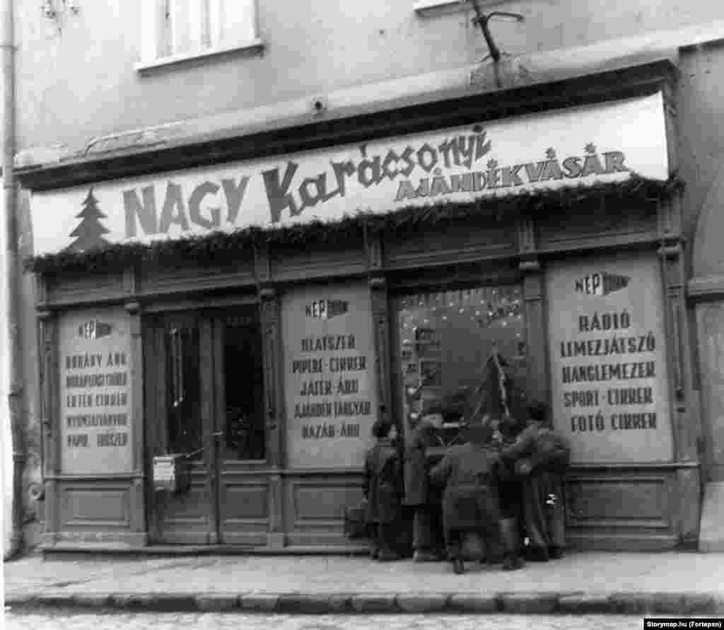 Gyerekek nézegetik a játékokat egy szentendrei bolt kirakatában 1954 karácsonya előtt