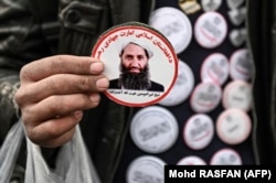 A man holds stickers depicting Taliban supreme leader Mullah Haibatullah Akhundzada at a market in Kabul. (file photo)