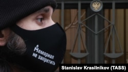 A man wears a face covering with a message reading "There Is No Way To Ban Memorial" outside the Supreme Court of Russia in December.