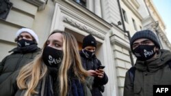 Активисти с маски с логото на "Мемориал" пред сградата на съда във вторник