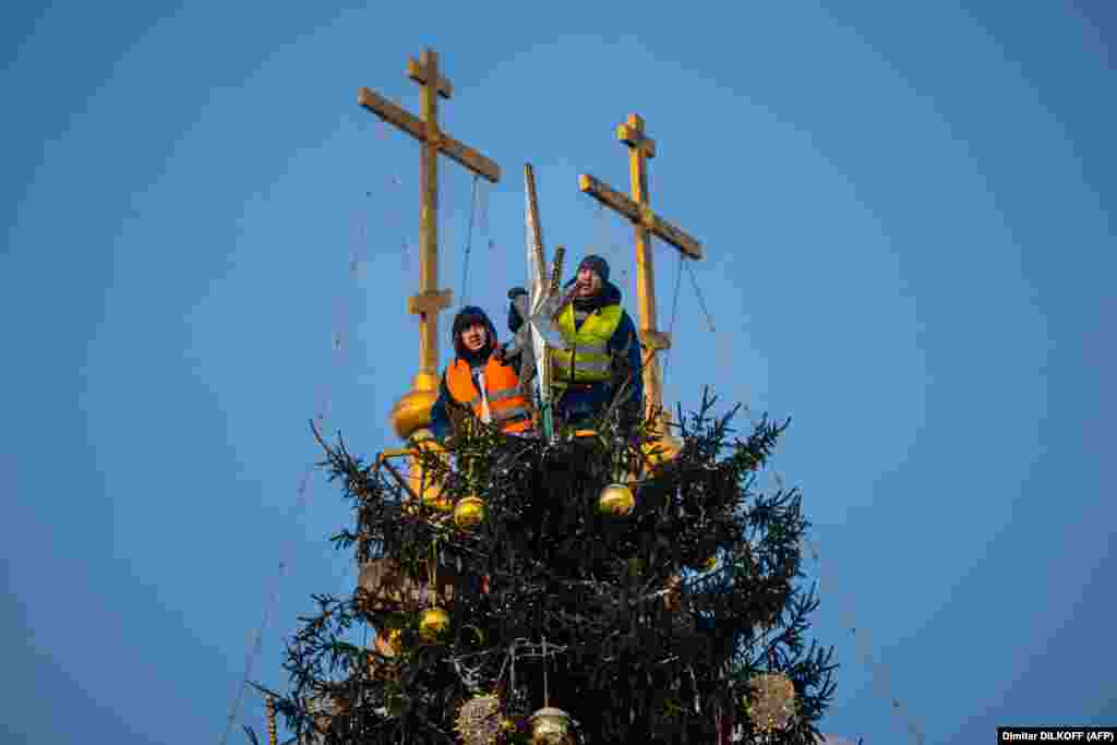 Workers decorate Russia&#39;s 28-meter-high New Year tree on the Kremlin&#39;s Sobornaya Square in downtown Moscow.&nbsp;