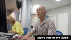 Томск. Пожилые мужчина и женщина обучаются работе за компьютером