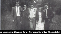 Снимка на петима души, осъдени през 1985 г. за протестите им срещу насилствената асимилация на българските турци. Втората отляво е Зейнеп Зафер. Снимката е правена в селото, в което са изселени повечето от хората на снимката. Петимата са облечени в същите дрехи, в които са били към момента на ареста им. С. Черни връх, днешна област Монтана, между 1986 и 1988 г.