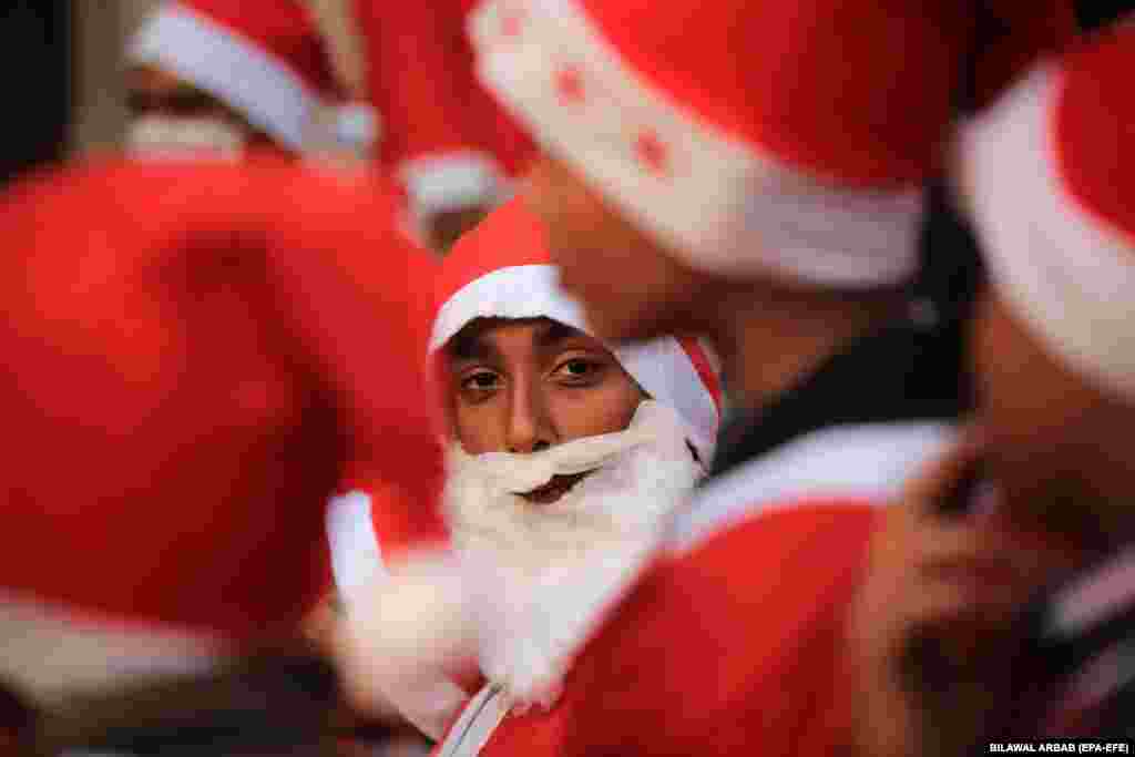 Members of Pakistan&#39;s Christian minority dressed as Santa Claus attend a pre-Christmas rally on a street in Peshawar.&nbsp;
