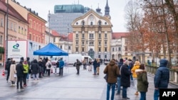 Tesztelésre várók a ljubljanai Kongresszusi téren, a mobil Covid-tesztelő egység előtt 2020. december 22-én.