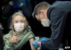 Міністр охорони здоров’я Німеччини Карл Лаутербах робить щеплення 10-річний дівчині на ім’я Фріда. Ганновер, Німеччина, 17 грудня 2021 року