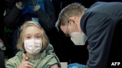 Njemački minstar zdravlja Karl Lauterbah vakciniše djevojčicu Fridu protiv korona virusa, Hanover, 17. decembar 2021.