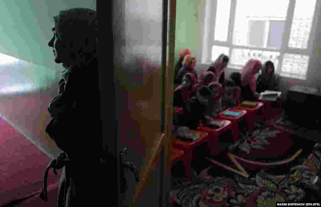 Zahria Erian (left) takes a moment outside the room where she gives lessons at her home in Kabul for a mixed group of Afghan children. The new Taliban regime has kept nearly 1.1 million Afghan girls away from schools.