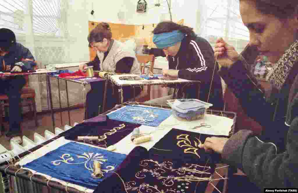 Ethnic Tatar women sewing textile items with ornek patterns in Crimea in 2004. Ornek is a system of artistic symbolism that is used in embroidery, weaving, pottery, engraving, jewelery, wood carving, and glass and wall painting.