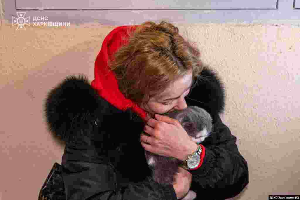 Жителька Харкова обіймає свого кота, перебуваючи вже в безпеці. Оскільки багатоквартирний будинок, в якому жінка живе, був пошкоджений ударом російського безпілотника під час чергового нападу Росії на Україну. Харків, 24 січня 2026 року
