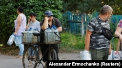 Місцеві стоять у черзі за водою до автоцистерни в окупованому Донецьку, 29 липня 2025 року
