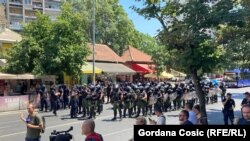 Građani na trotoaru nakon što im je policija zatražila da se sklone sa kolovoza na barikadi u Zemunu, 30. jun 2025.