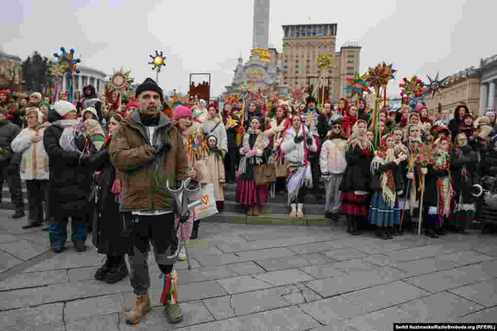 Чоловік із протезом ноги серед колядників. Протез прикрашений різдвяними стрічками