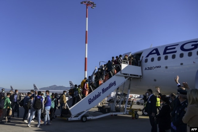 Неповнолітні мігранти, які проживали в таборах на грецьких островах, сідають на літак в Афінах, щоб вилетіти спеціальним рейсом до Німеччини, 18 квітня 2020 року