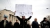 An anti-government protester holds a placard reading, "Europe, you owe us, do you remember 1992-1995?" during a protest in Sarajevo.