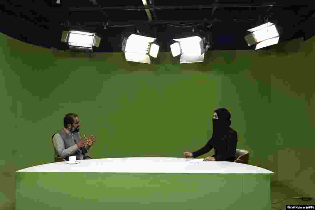 After: A female television presenter (right) interviews a guest in a studio in Kabul in May 2022. Soon after coming to power, Taliban leadership called on female presenters to cover their faces.