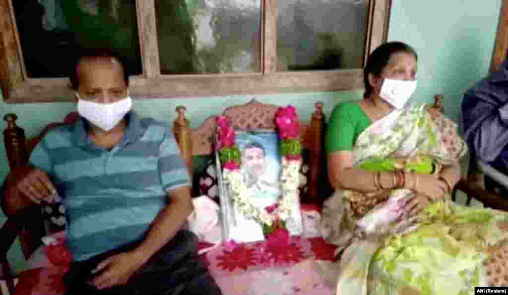 The father and mother of Colonel Santosh Babu, who was killed in border clashes with Chinese troops, sit next to his portrait, in Suryapet,Telangana state, India June 17, 2020 in this still image from video.