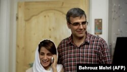 IRAN -- Lawyer Nasrin Sotoudeh (L) speaks on the phone next to her husband Reza Khandan as they pose for a photo at their house in Tehran, September 18, 2013