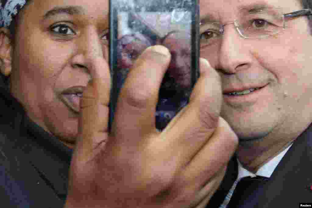 A woman takes her picture with French President Francois Hollande as he visits the Gresilles neighborhood in Dijon at the start of a two-day trip. (Reuters/Philippe Wojazer)