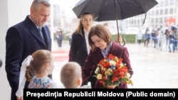 Maia Sandu, alături de președintele slovac Peter Pellegrini, primind flori de la doi copii în timpul vizitei sale oficiale la Bratislava.