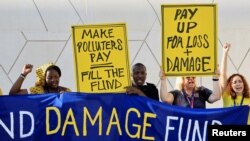 Activiștii pentru mediu cer ca firmele și țările cele mai poluante să plătească daunele și pierderile suferite de țările sărace în urma dezastrelor naturale. Dubai, 4 decembrie.