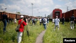 Ziariști adunați în gara Harkov la sosirea trenului cu rămășițele pămîntești ale celor uciși în catastrofa aviatică din Ucraina de est