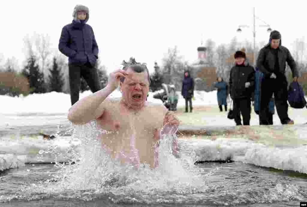 A Russian Orthodox believer takes a dip in icy water during celebrations of Epiphany in Moscow. People believe that plunging themselves into blessed waters during Epiphany strengthens their spirit and body. (epa/Maxim Shipenkov)