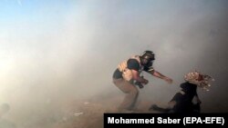 Фотажурналіст спрабуе дамапагчы ўдзельніцы дэманстрацыі