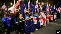 Protesters carry Georgian and EU flags in Tbilisi on November 17 in a "disobedience campaign" to protest the disputed elections.