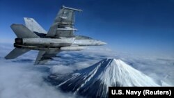 Американский палубный истребитель F/A-18F Super Hornet над горой Фудзи в Японии. В 2017 году командование Военно-морской авиации США планировало обеспечить специальными "умными" часами Garmin всех пилотов таких самолетов