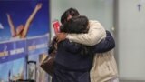 GERMANY -- People among the first evacuees from Kabul, hug as they arrive at Frankfurt International Airport in western Germany in the early hours of August 18, 2021.