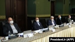 Cabinet members wear a protective mask and gloves as means of protection against the cornonavirus COVID-19, during a cabinet meeting in the capital Tehran, March 11, 202