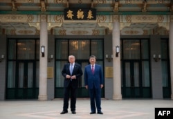 Președintele SUA, Donald Trump, alături de președintele chinez Xi Jinping în timpul unei vizite la Grădina Zhongnanhai din Beijing, pe 15 mai.