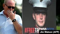 Joey Reed, the father of former U.S. Marine Trevor Reed, stands next to a placard of his son outside the U.S. Capitol in Washington in July.