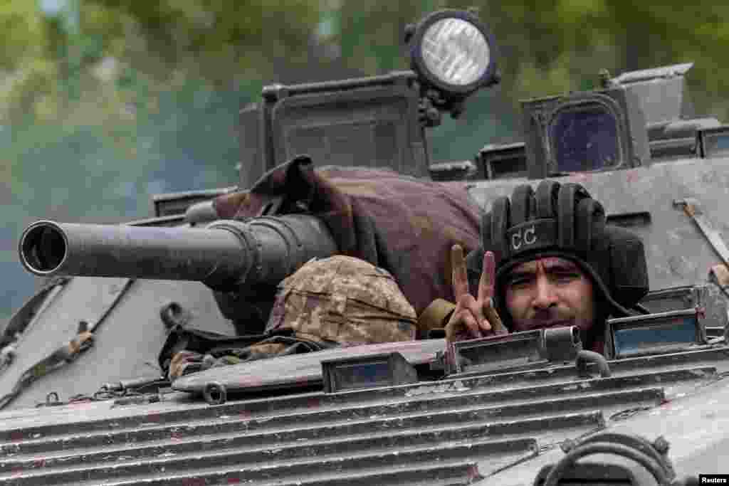 An Ukrainian service member rides on top of a military vehicle, amid Russia&#39;s invasion of Ukraine, on the road from Bakhmut to Kostyantynivka, in the Donetsk region.