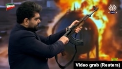 An Iranian state TV presenter fired at a United Arab Emirates flag during a broadcast amid signs of growing public militarization in Iran.