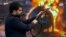 IRAN --- Iranian TV Presenter Fires Gun At UAE Flag Amid Growing Public Militarization