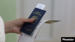 Armenia - A voter prepares to cast a ballot in parliamentary elections at a polling station in Yerevan, June 7, 2026. 