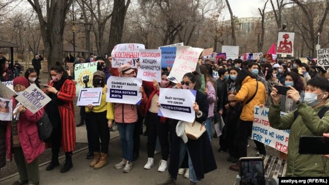 Плакаты в руках участниц акции. Алматы, 8 марта 2021 года.