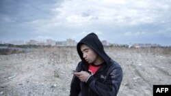 A Tajik migrant worker in Russia texts a message home.