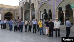 Iranians line up to vote in Tehran in the country's July 5 presidential runoff election.